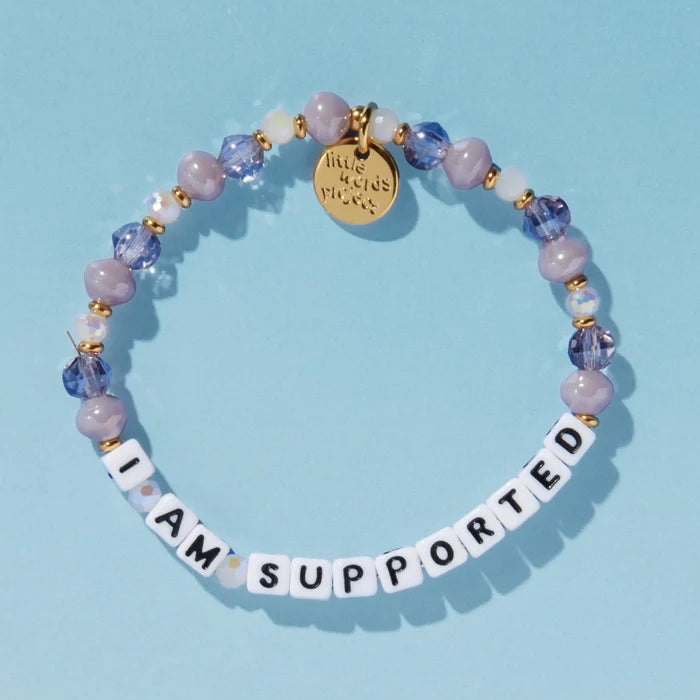 I Am Supported beaded bracelet with grey stones against a blue background