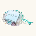 "Mindful Meditation" DIY bead kit with scattered blue, white, and purple beads, letter beads, and a teal stretchy cord.