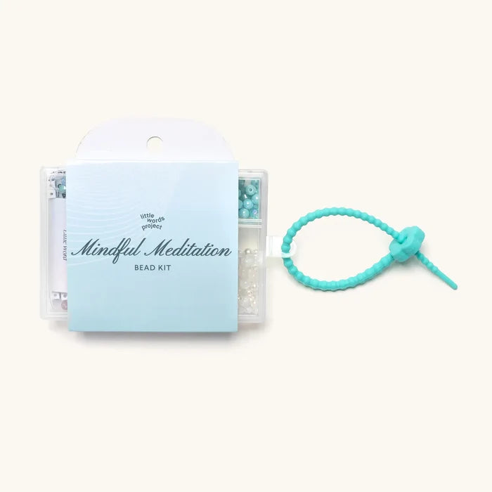 "Mindful Meditation" bead kit box alongside a teal knotted silicone bracelet.