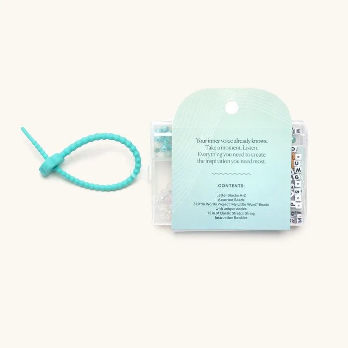 Back of the "Mindful Meditation" bead kit showing contents list and a teal knotted silicone bracelet.