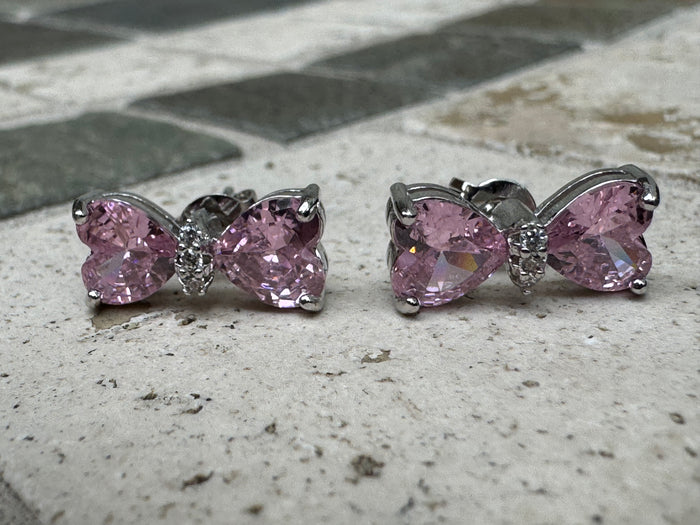Silver-toned statement earrings featuring pink heart-shaped crystals and pave crystal