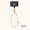 Little Words Project beaded phone strap in soft blue, white, and gold tones with a spinning gold bar charm.